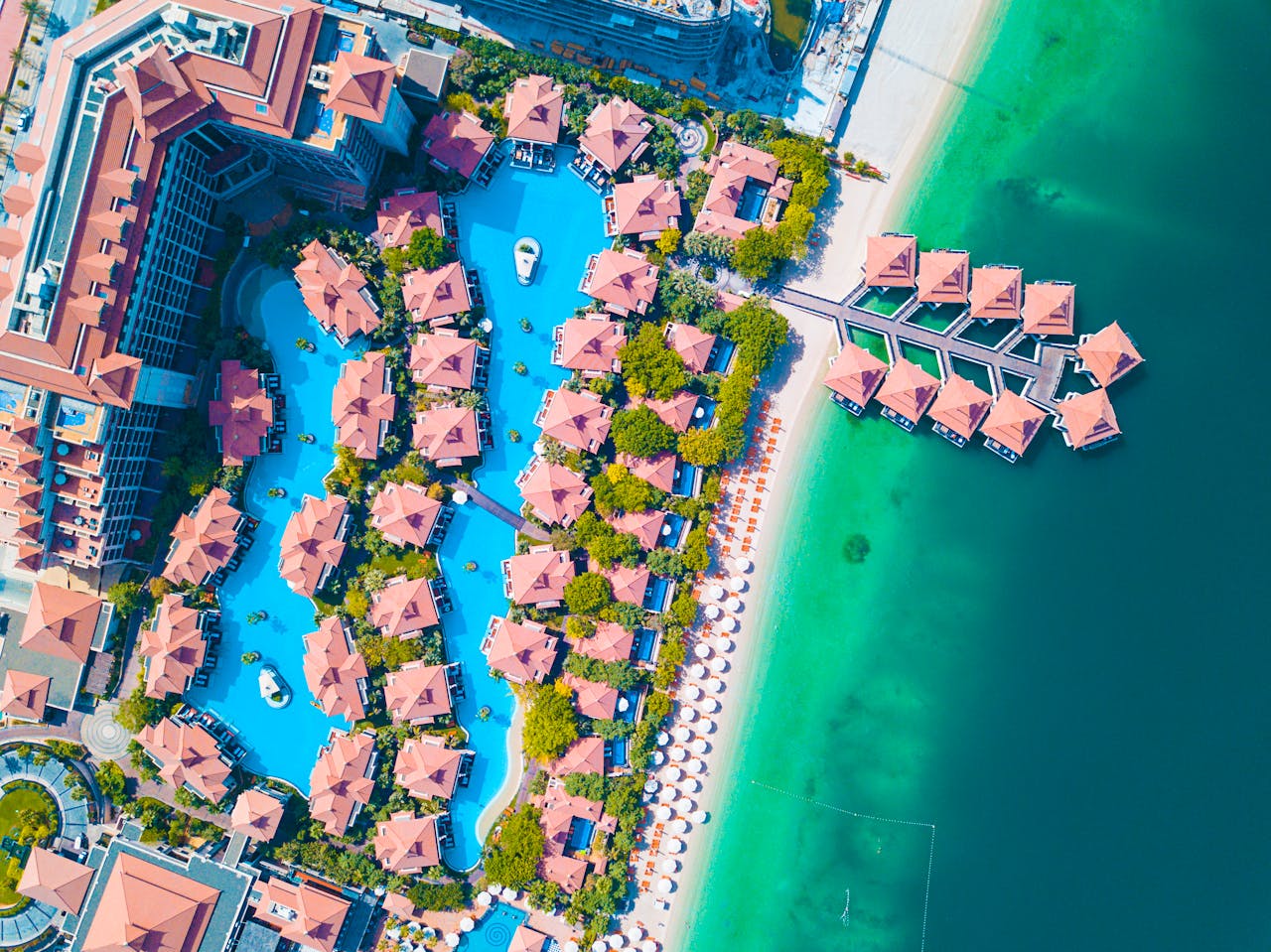 about-us Stunning aerial shot of a luxurious Dubai beachfront resort with swimming pools.