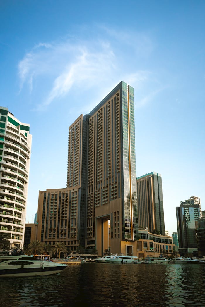 services-02 A view of modern skyscrapers and luxury yachts in Dubai Marina under a clear blue sky.